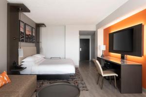 a hotel room with a bed and a flat screen tv at Fort Lauderdale Marriott Coral Springs Hotel & Convention Center in Coral Springs