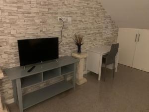 a living room with a tv and a table with a tableablish at Appartement en zone pavillonnaire in Drancy