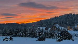 a sunset over a ski lodge in the snow at Osada Beskidzka in Zawoja +170 photos