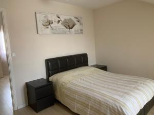um quarto com uma cama e duas mesas de cabeceira em Appartement en zone pavillonnaire em Drancy