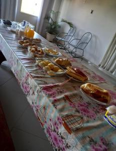 a table with pastries and orange juice on it at Pousada residencial in Curvelo