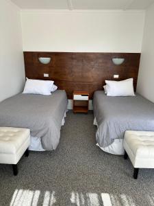 a room with two beds and a bench in it at American Hotel in Los Vilos