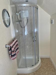 um chuveiro com uma porta de vidro na casa de banho em Knighton Lodge em Skegness