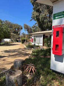 una caja de postes roja en el lateral de un edificio en American Hotel en Los Vilos