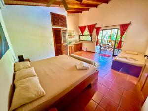 a bedroom with a large bed and a kitchen at Pacifica Surf Studios in Santa Teresa Beach