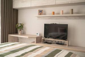 a bedroom with a flat screen tv and a bed at RentWill apartments Sixteen in Chişinău