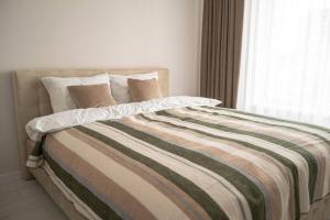 a bed with a colorful blanket and pillows on it at RentWill apartments Sixteen in Chişinău