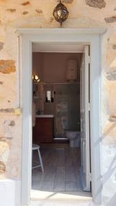 une porte menant à une salle de bains pourvue de toilettes. dans l'établissement Christina's Stone House Apartment, à Hydra