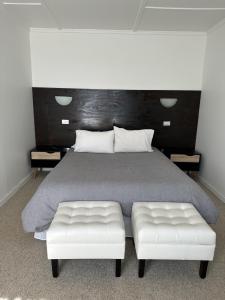a bedroom with a large bed with two white seats at American Hotel in Los Vilos