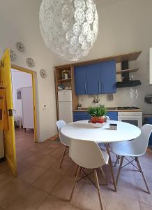 eine Küche mit einem weißen Tisch und weißen Stühlen in der Unterkunft Il Balconcino sul carugio in Monterosso al Mare