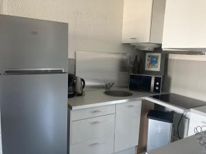 a small kitchen with a refrigerator and a sink at A LA DECOUVERTE DE NICE in Nice