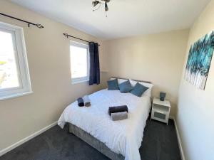 Un dormitorio con una cama y dos ventanas. en Cliff Haven, Sea View Holiday Home., en Cullercoats
