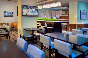 a restaurant with tables and chairs and a tv at Courtyard by Marriott New York Manhattan/Chelsea in New York