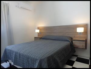 a bedroom with a bed with two lights on it at Hotel Low Cost Bahía in Bahía Blanca