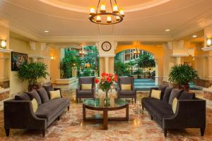eine Lobby mit Sofas und einem Tisch mit Blumen in der Unterkunft Four Points by Sheraton Suites Tampa Airport Westshore in Tampa