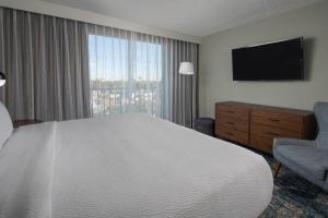 Habitación de hotel con cama y TV en Four Points by Sheraton Suites Tampa Airport Westshore, en Tampa