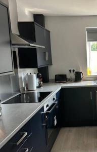 a kitchen with black and white cabinets and a sink at Seaside Retreat In Saltburn! in Saltburn-by-the-Sea