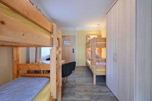 フュッセンにあるRote Villa Füssenの二段ベッドとデスクが備わるドミトリールームです。