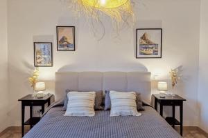 a bedroom with a bed with pillows and two tables at El Bruni - modern villa close to the beach in Benissa in Pedramala