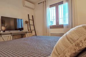 1 dormitorio con 1 cama y TV de pantalla plana en El Bruni - modern villa close to the beach in Benissa, en Pedramala