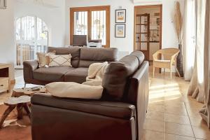 a living room with a leather couch and a table at El Bruni - modern villa close to the beach in Benissa in Pedramala