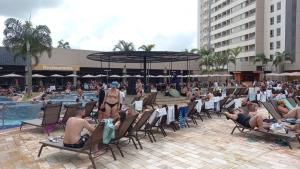 eine Gruppe von Personen, die an einem Pool auf Stühlen sitzen in der Unterkunft Solar das Águas Park Resort in Olímpia