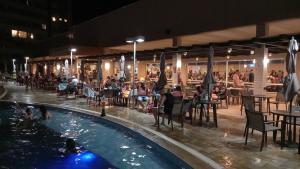 ein Pool in einem Restaurant mit Leuten, die an Tischen sitzen in der Unterkunft Solar das Águas Park Resort in Olímpia + 9 Fotos