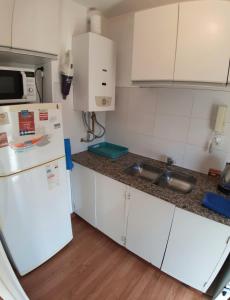 a kitchen with a white refrigerator and a sink at Espacio C Av Marcelo t de Alvear Vista Centro in Córdoba +8 photos