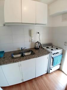 a white kitchen with a stove and a sink at Espacio C Av Marcelo t de Alvear Vista Centro in Córdoba