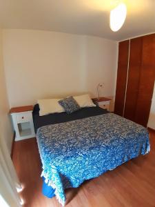 a bedroom with a bed with a blue comforter at Espacio C Av Marcelo t de Alvear Vista Centro in Córdoba