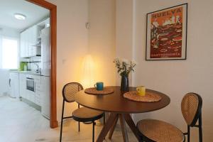 uma mesa de jantar com cadeiras e uma mesa com duas chávenas em Apartamento Toledo 8 em El Rompido