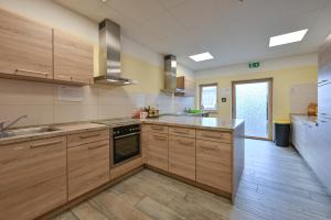 uma grande cozinha com armários de madeira e electrodomésticos de aço inoxidável em Rote Villa Füssen em Füssen