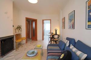 uma sala de estar com um sofá azul e uma lareira em Apartamento Toledo 8 em El Rompido