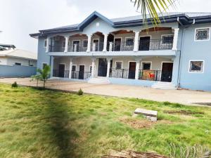 a blue house with a lawn in front of it at ND SMART RESIDENCE in Limbe