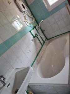 a bath tub with a hose hooked up to a sink at ND SMART RESIDENCE in Limbe
