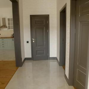 korytarz z dwoma drzwiami i białą podłogą wyłożoną kafelkami w obiekcie Chilagir_garden w mieście Qusar