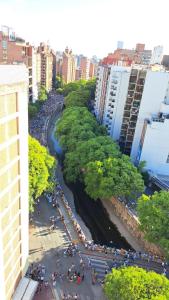 a group of people walking along a river in a city at Espacio C Av Marcelo t de Alvear Vista Centro in Córdoba