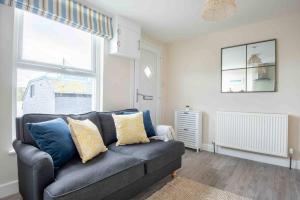 un salon avec un canapé bleu et une fenêtre dans l'établissement The Little Loft St Ives, à St Ives