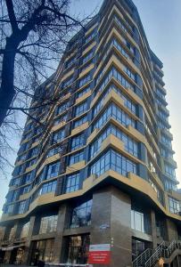 een groot hoog gebouw met veel ramen bij LAMIYA Aparts Hotel in Alma-Ata