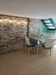 una sala da pranzo con tavolo, sedie e muro di mattoni di Napoli nel cuore a Napoli