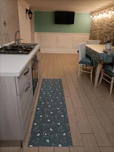 une cuisine avec une cuisinière et une table avec un tapis dans l'établissement Napoli nel cuore, à Naples