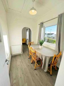 uma sala de jantar com uma mesa e cadeiras e uma janela em McBride's Bungalow, Chapel Road Dungloe em Donegal