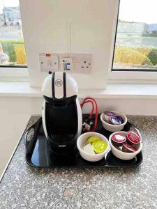 a tea kettle on a tray on a counter with bowls at McBride's Bungalow, Chapel Road Dungloe in Donegal