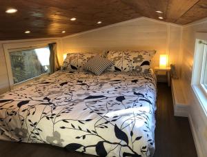 ein Schlafzimmer mit einem Bett in einem winzigen Haus in der Unterkunft Modern Private Tiny House in the Forest in Slocan