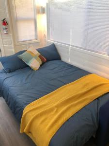 a bed with blue sheets and pillows in a bedroom at Modern Private Tiny House in the Forest in Slocan