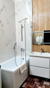 a white bathroom with a tub and a sink at LAMIYA Aparts Hotel in Almaty