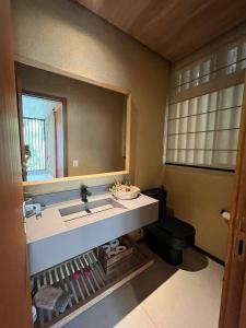ペトロポリスにあるCasa 16 da Villa - Fazenda Marambaiaの洗面台、鏡、トイレ付きのバスルーム