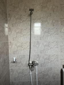 a shower in a bathroom with a stone wall at Дом в аренду - Kharberd House, долгосрочная и краткосрочная аренда in Yerevan