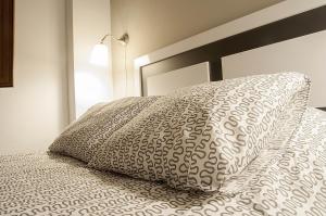 a bed with a pillow on top of it at Apartamentos Catedral Plaza 3000 in Granada