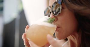 a woman eating a drink with a piece of food in her mouth at Wailea Beach Resort - Marriott, Maui in Wailea